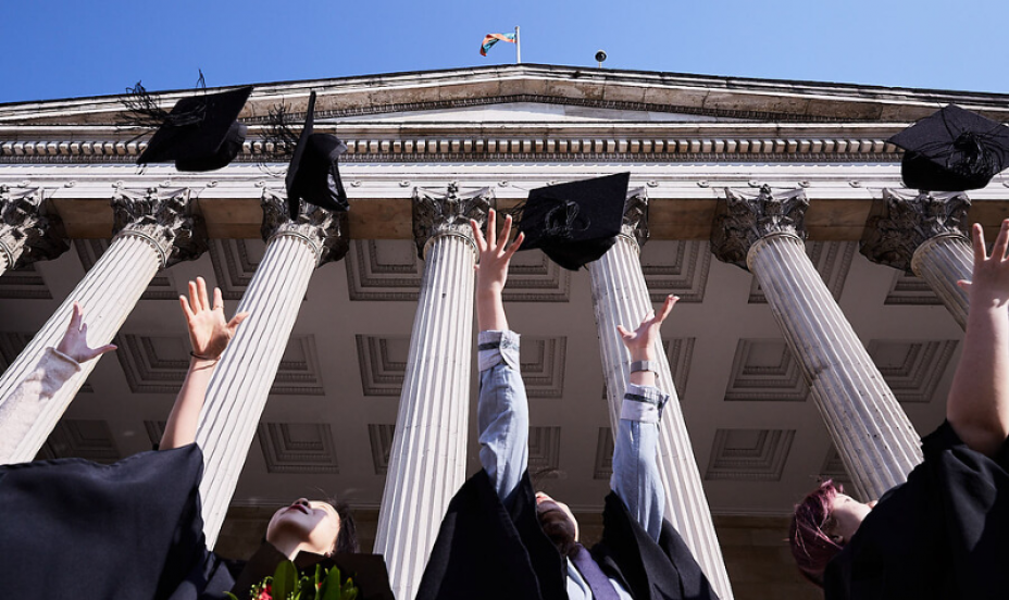 ׼ϲ̳ Graduates through caps into the air. 